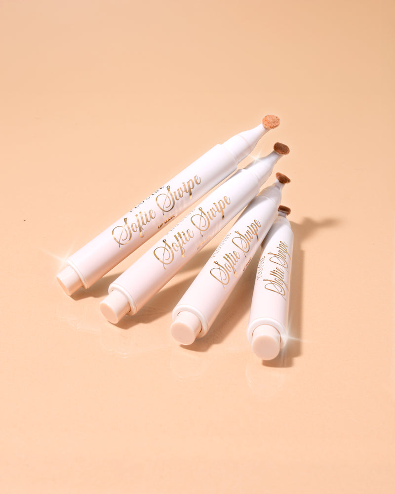 Een afbeelding van vier P.Louise Softie Swipe Tinted Lip Masks in de geur van kokoscake, op elkaar gestapeld met een beige achtergrond