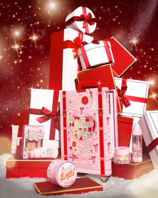 Pink P.Louise Wrapped & Ready gift set with a festive design surrounded by luxury christmas gift boxes on a red background