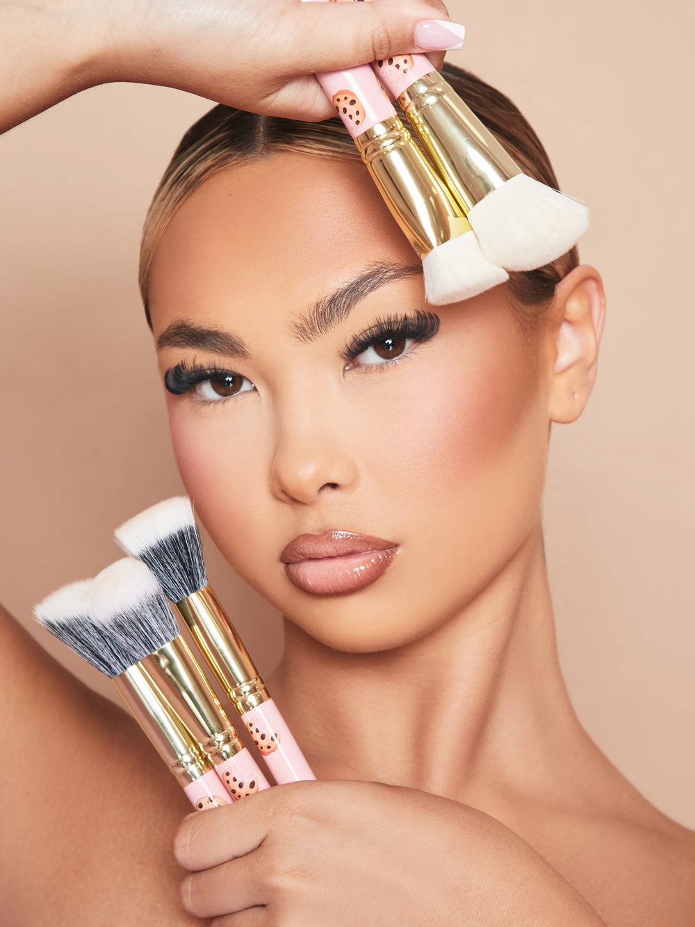 Een afbeelding van een vrouwelijk model dat make-up draagt en de P.Louise Spoiled For Choice 5-delige make-upborstelset tegen haar gezicht houdt