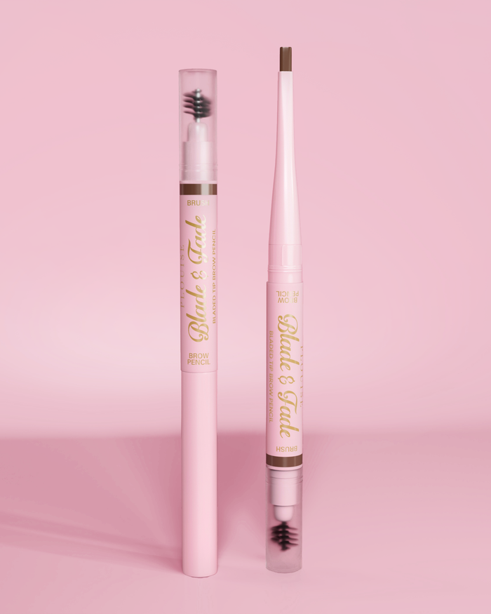 Une image de deux crayons à sourcils P.Louise Blade & Fade avec pinceau, l'un avec le couvercle posé et l'autre sans le couvercle, montrant la lame sur un fond rose.