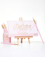 Een gesloten roze P.Louise Creative Comeback XXXL Rainbow Eyeshadow Palette geplaatst op een kunstezel omringd door make-upborstels