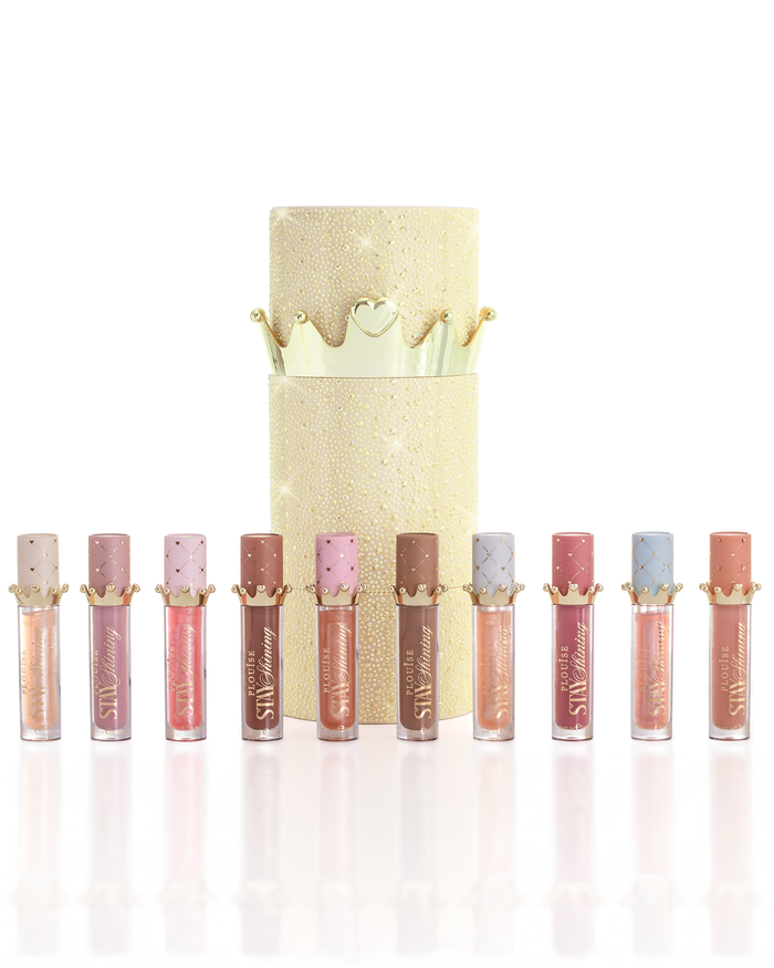Een set van tien P.Louise Christmas stay glanzende lipolieproducten, gerangschikt in een rij voor een glitterende gouden cilindrische lipoliedoos met een gouden kroondeksel, op een schone witte achtergrond.