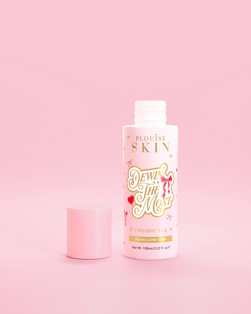 Roze fles P.Louise Dewin The MOst Double Layer Toner met rode strikjes tegen een roze achtergrond 
