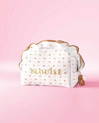 Une trousse de maquillage et de soin à volants P.louise avec un motif ours en peluche imprimé odeur sur fond rose