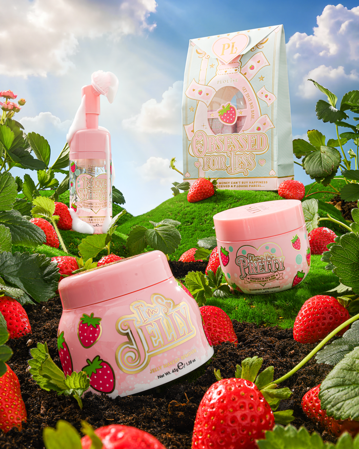 P.Louise Strawberry Obsessed For Less Double Cleanse & Moisturise Skincare Gelegen op een met gras begroeide heuvel omringd door aardbeien