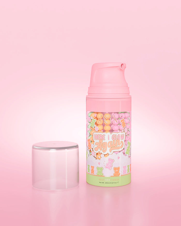 Paarse fles P. Louise Here I Glow Again Candy Bears Recovery Mask op een roze achtergrond