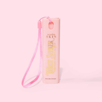 Roze mini sleutelhanger reisformaat P.Louise dorstzoeker hydraterende setting spray met een bandje op een roze achtergrond
