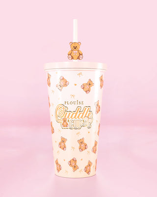 Steel tumbler cup with straw and a teddy bear design with 'Cuddle Cup' text on a pink background
