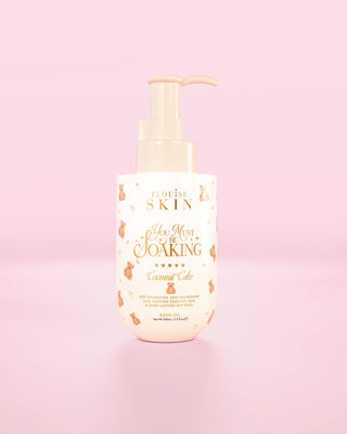 Bouteille de l'huile de bain P.Louise You Must Be trempage dans un gâteau à la noix de coco sur fond rose